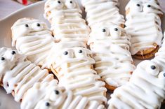 there are many cookies with icing and eyes on the top one is made to look like ghost faces