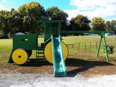 a green and yellow playground set with a slide