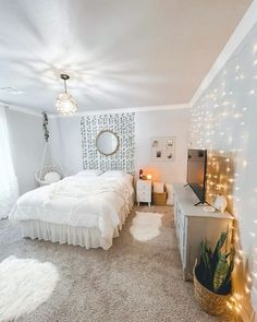 a bedroom with white bedding and lights on the walls, carpeted flooring