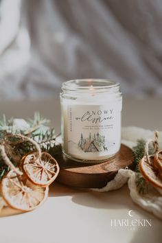 a candle sitting on top of a table next to sliced oranges and pine cones