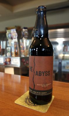 a bottle of beer sitting on top of a wooden table