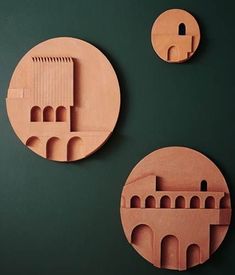 three pieces of paper cut out to look like architecture