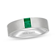 a men's ring with a green stone in the center and an inscription on the side