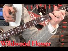 a man playing an electric guitar with the words wildwood flower on it