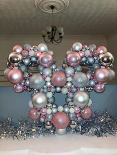 a large balloon shaped like the letter k with ornaments on it's sides and hanging from a chandelier