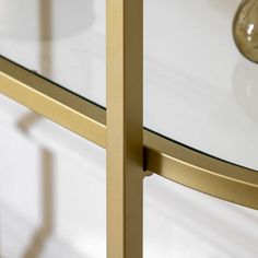 a glass and brass table with a light bulb on top