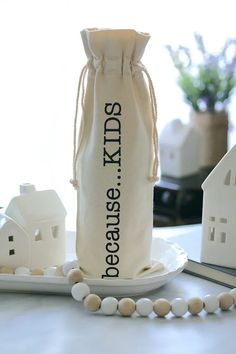 a bag that is sitting on top of a plate next to some small houses and beads