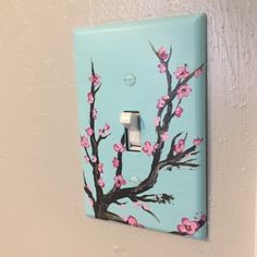 a light switch cover with pink flowers painted on it