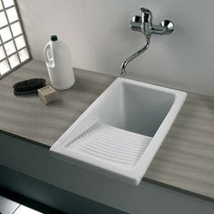 a white sink sitting on top of a wooden counter