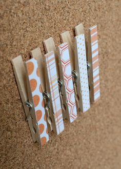 some paper clips are attached to a bulletin board that is hanging on a corkboard