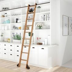 a ladder leaning up against a white bookcase in a room filled with books and vases