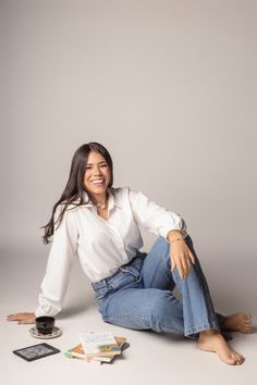 a woman is sitting on the floor with her legs crossed and smiling at the camera