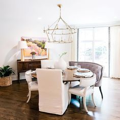 the dining room table is set with white chairs