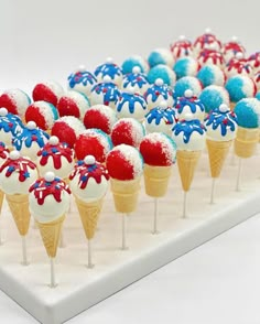 red, white and blue ice cream cones with sprinkles in them on a tray