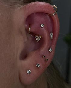 a close up of a person's ear with several small diamond studs on it