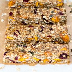 granola bars are lined up on a piece of parchment paper and ready to be eaten