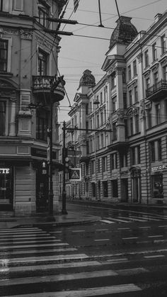 an empty street with buildings on both sides and a traffic light hanging over the road