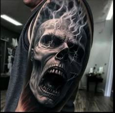 a man's arm with a skull on it and lightning coming out of his head