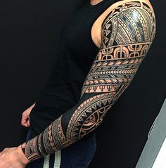 a man with a black and grey tattoo on his arm