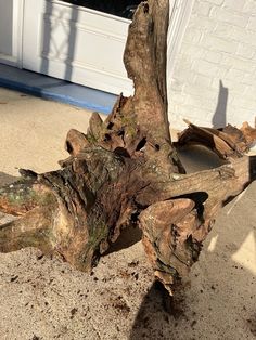 a piece of wood sitting on top of a sidewalk next to a white brick building