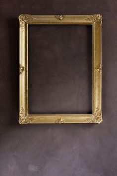 an old gold frame hanging on the wall with a brown background and no one is in it