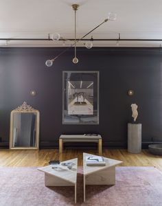 a living room filled with furniture and a painting on the wall above it's coffee table