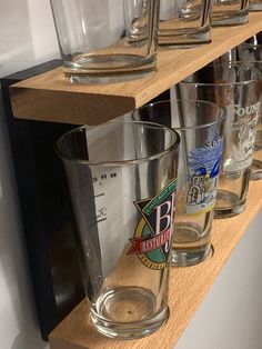 several shot glasses are lined up on a shelf next to each other in a row