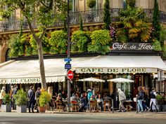 people are walking around in front of cafe de flore