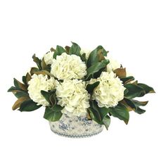 a white flower arrangement in a blue and white vase on a white background with greenery