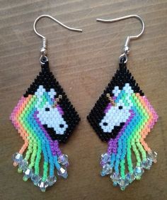 a pair of beaded earrings with a rainbow unicorn on it's earwires