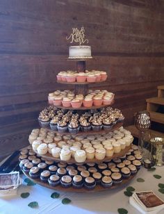 a three tiered cake with cupcakes on it