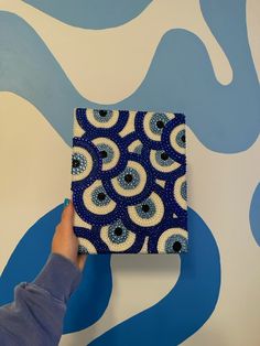 a person is painting a wall with blue and white designs