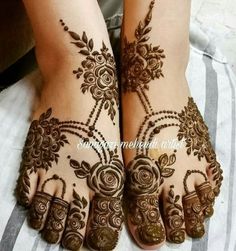 two feet with henna tattoos on them, one is showing it's intricate designs