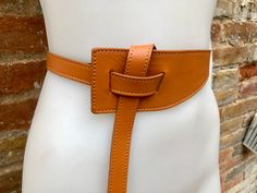 "NEW STYLE. Camel brown  OBI BELT in  genuine leather. Waist belt in soft natural leather. Saddle brown color 80s style belt. One side \"passes through\" the other through the 2 eyelets and then can be either hidden behind or passed through again at the front, please see pictures!  Available in gray, burgundy, mustard yellow, black and taupe color ( light brown-dark greyish beige) The belt is 116 cm (46 in) long   6 cm (2  1/2in) wide at one side and 2 cm ( 3/4 in) at the other side  Our genuine Brown Fitted Leather Belt, Adjustable Brown Belt With Self Belt Detail, Fitted Brown Leather Belt, Adjustable Brown Belt, Chic Adjustable Brown Belt, Adjustable Brown Corset Belt With Matching Belt, Adjustable Leather Belted Belts And Suspenders, Brown Leather Corset Belt With Removable Belt, Spring Leather Corset Belt