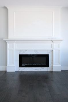 an empty room with a fireplace and white walls