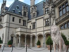 a statue of a lion in front of a large building