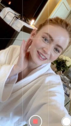 a woman in a bathrobe is taking a selfie