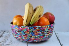 a bowl filled with fruit sitting on top of a wooden table