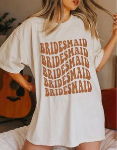 a woman wearing a white t - shirt that says bridesmaid on the front