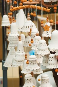 a group of bells hanging from the ceiling in front of a store display case with other items on it