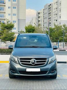 the front view of a mercedes benz s - class parked in a parking lot next to tall buildings