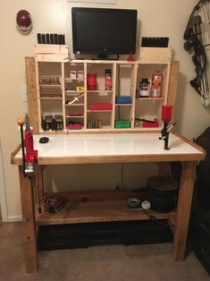 a workbench made out of wood with tools and supplies on the top shelf