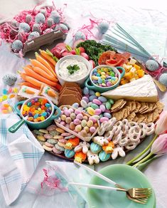 a platter filled with candy, crackers, and other food on a table