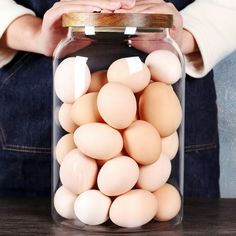 a person holding a jar filled with eggs