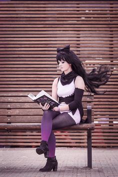 a woman sitting on a bench reading a book