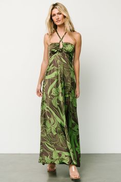 FINAL SALE Add a touch of retro and chic to your wardrobe with this perfect dress! Vibrant green floral pattern on brown background Light weight satin material with no stretch Straight relaxed fit Halter neck ties Trendy U detail at bust Grippy non slip strips at bust Smocked back Hidden back zipper Left leg slit Attached lining till knee Self: 100% Polyester Lining: 100% Polyester Skye is 5'9, cup size 32A, size 0 and wearing size S Green Halter Neck Dress, Background Light, Green Floral Pattern, Baltic Born, Brown Background, Neck Ties, Halterneck Dress, Satin Material, Vibrant Green