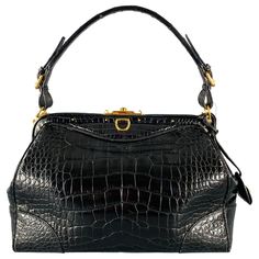 RALPH LAUREN COLLECTION handbag in a black fabric featuring a doctor's bag style with top handles, alligator pattern, and push lock closure. Comes with key.Very Good Pre-Owned Condition. Light wear. Measurements: Length: 14 inches Width: 5.5 inches Height: 8.5 inches Drop: 7 inches Sui Generis Reference: 131603 Category: Handbag & Leather Goods More Details Brand: RALPH LAUREN Color: Black Color 2: Gold Type of Leather: Alligator Style Bag: Doctor Age Group: Adult Alligator Pattern, Cartier Panthere, Bracelet Love, Doctor Bag, Ralph Lauren Collection, Bag Style, Black Fabric, Fashion Handbags, Alligator