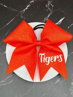 3" x 28" grosgrain dazzle ribbon with glitter heat transfer vinyl and ponytail elastic attached. Finished product 7" wide by 7" tall.  "Price per bow" All bows are customizable: we can do it in your colors, with your team name/ mascot/logo in YOUR budget, Just message me for information on how to place your custom order.  Materials and fabrics can be substituted. We do not warranty hair elastics as they are not manufactured by us. All custom orders and bows with names/initials/monograms etc are Glitter Heat Transfer Vinyl, Cheer Bow, Mascot Logo, Cheer Bows, We Can Do It, Hair Elastics, Bow Design, Monogram Initials, Transfer Vinyl