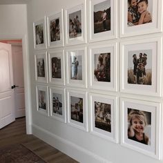 a wall with many pictures hanging on it's sides in a living room next to a door