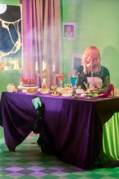 a woman sitting at a table with food on it and candles in front of her